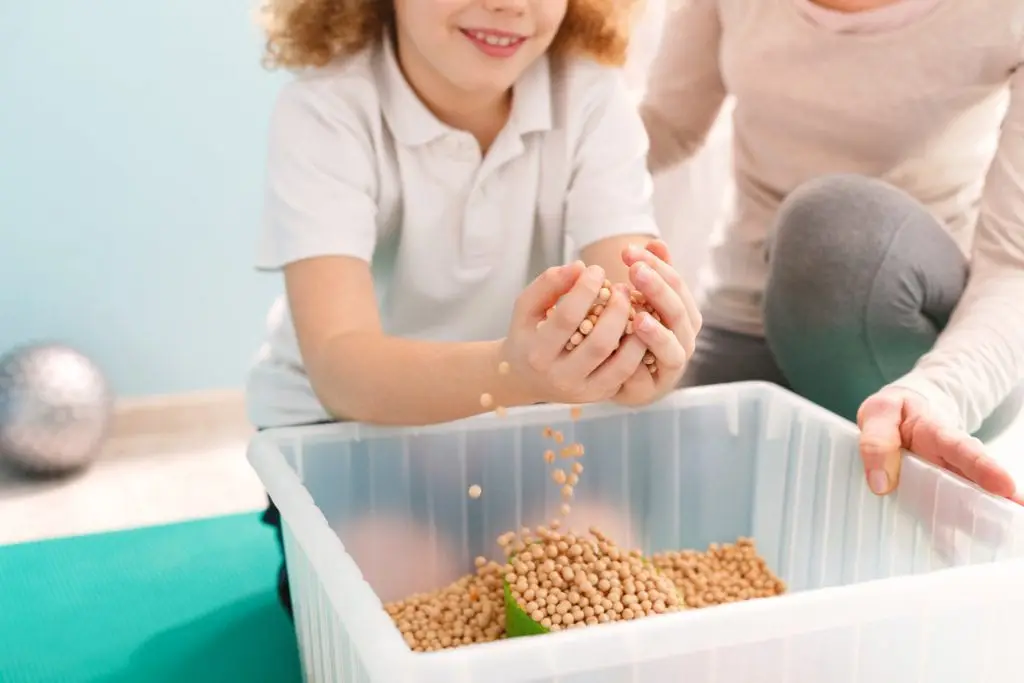 Occupational Therapy in Toronto, child playing with a sensory bin with therapist. 