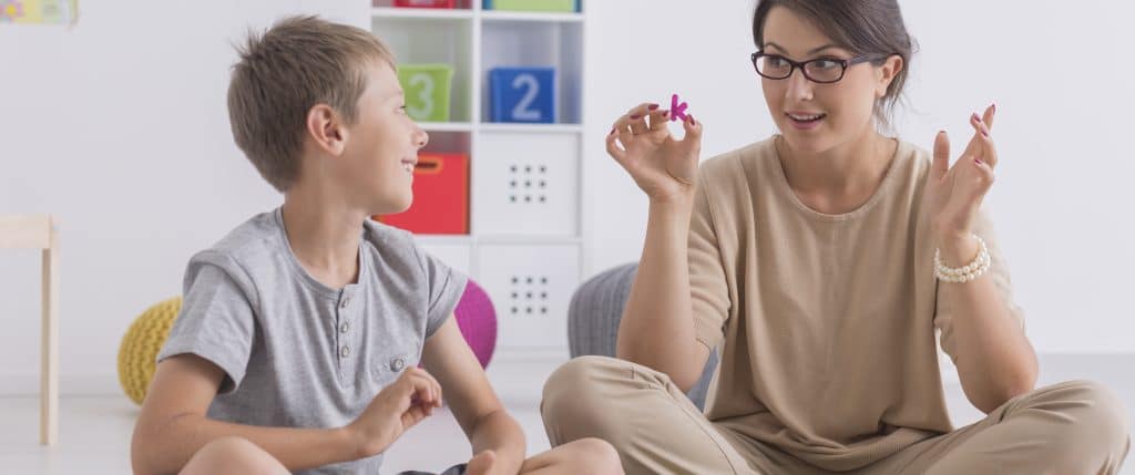 Speech Therapy in autism treatment with a young boy and a Speech-Language Pathologist
