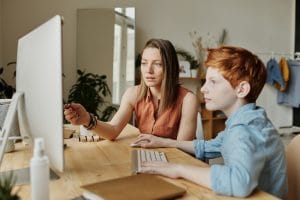 Therapist at a computer with a child. This individualized dynamic is what makes ABA effective. 